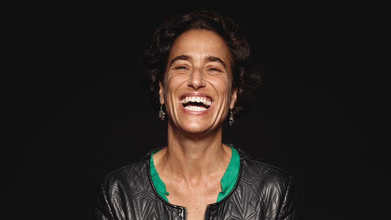 Close up of a laughing woman with short hair isolated on dark background