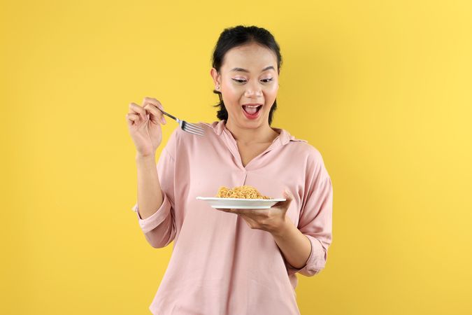 Happy Asian Woman, Using Fork Eating Instant Noodle or Mie Goreng on Plate