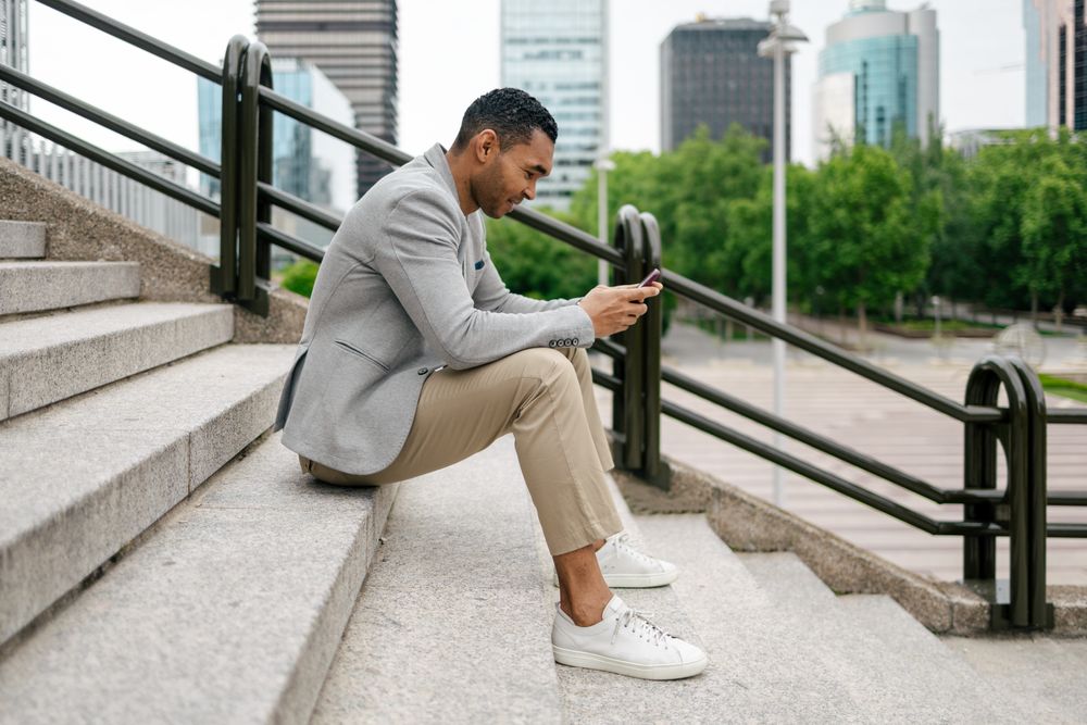 Man sitting on stairs using smartphone