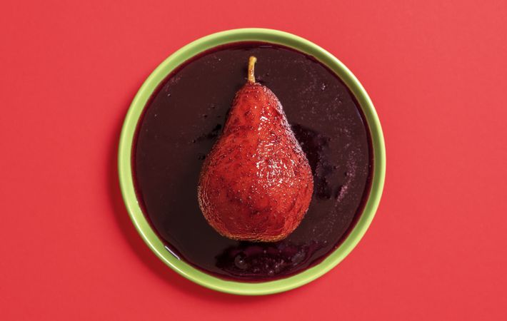 Red wine poached pear on the plate, above view