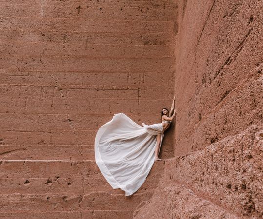 Elegant female posing on rocky cliff