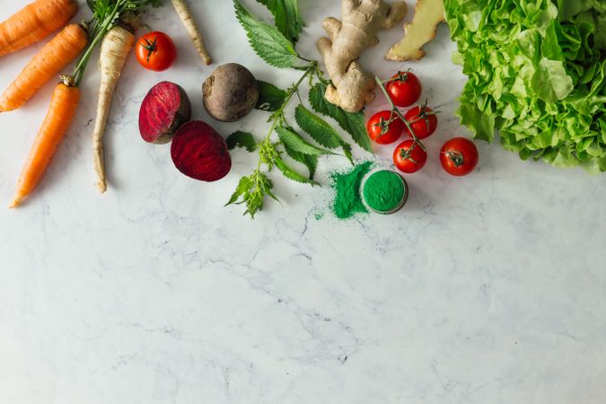 Fruits, vegetables and herbs on bright marble table background