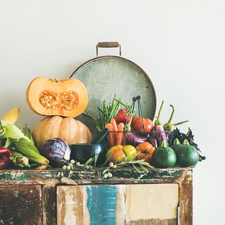 Fresh autumnal produce on kitchen counter, with halved squash and grey tray, square crop