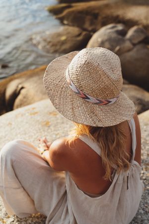 Carefree woman enjoying rest on coast near cliffs