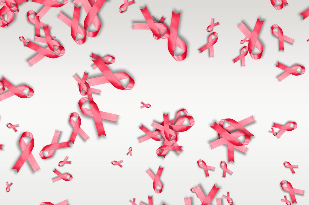 Scattered pink ribbons on bright background