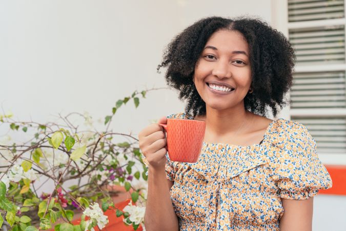 Woman sitting drinking coffee on the terrace of a house