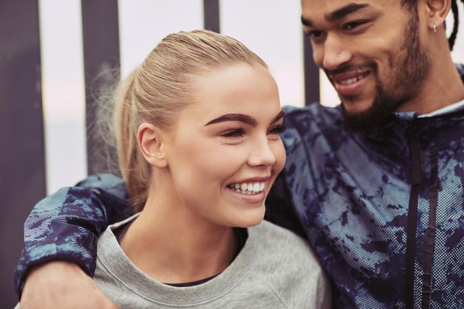 Close up of happy couple standing together outdoors before going for a run