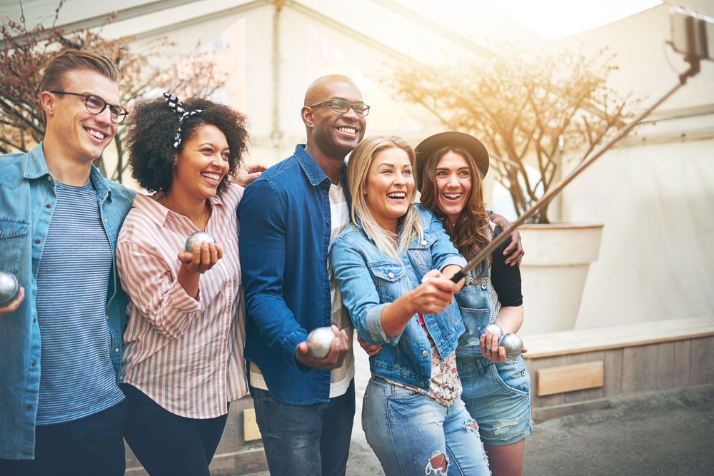 Multi-ethnic group of friends taking a picture of themselves outside