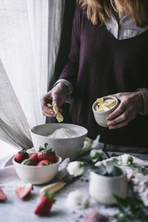 Crop woman preparing strawberry pastry