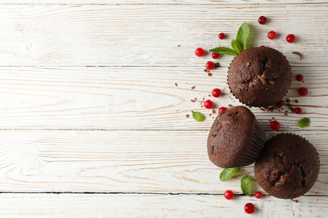 Composition with chocolate muffins and berries on wooden background