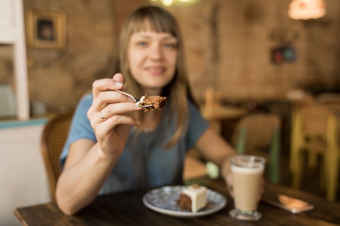 Woman holding spoon with slice of cake