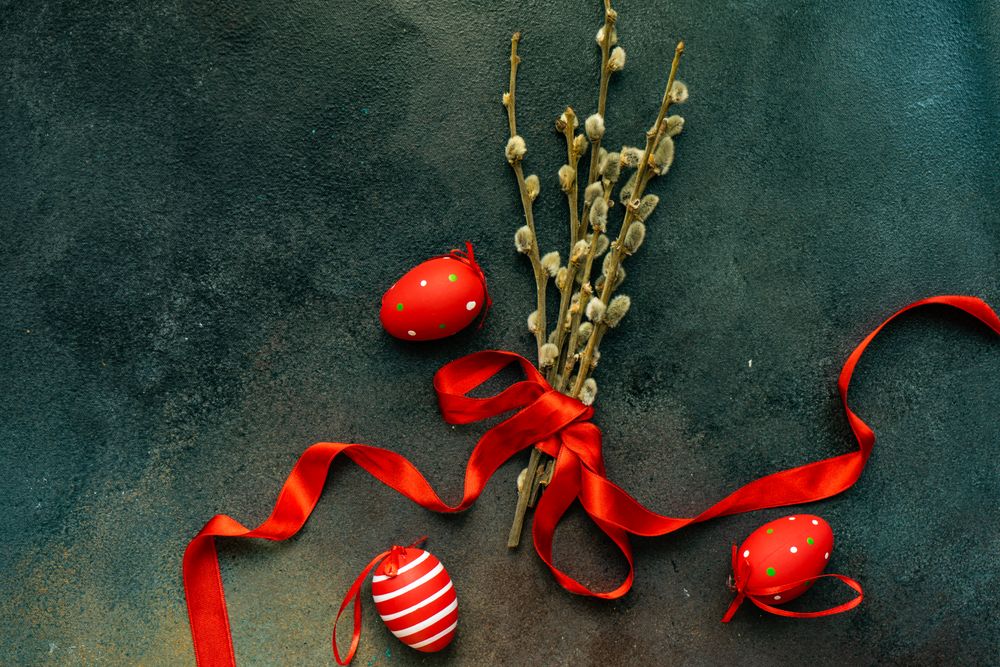 Red Easter decorations on grey table with pussy willow