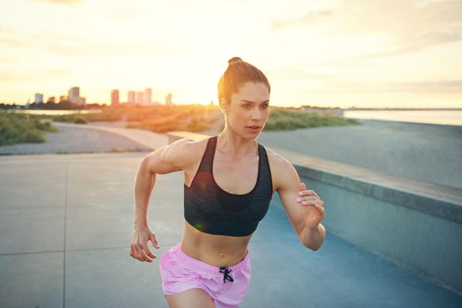 Woman in pink shorts sprinting in morning light