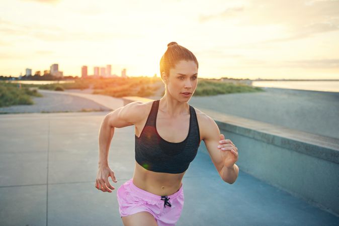 Woman in pink shorts sprinting in morning light