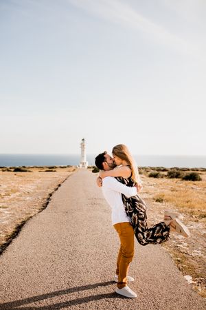 Happy lovers having fun on path from sea