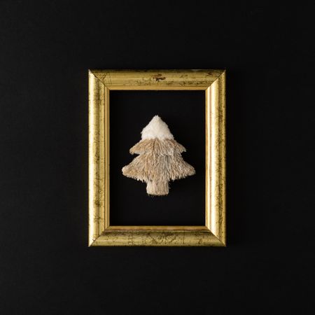 Gold frame with festive tree on dark background