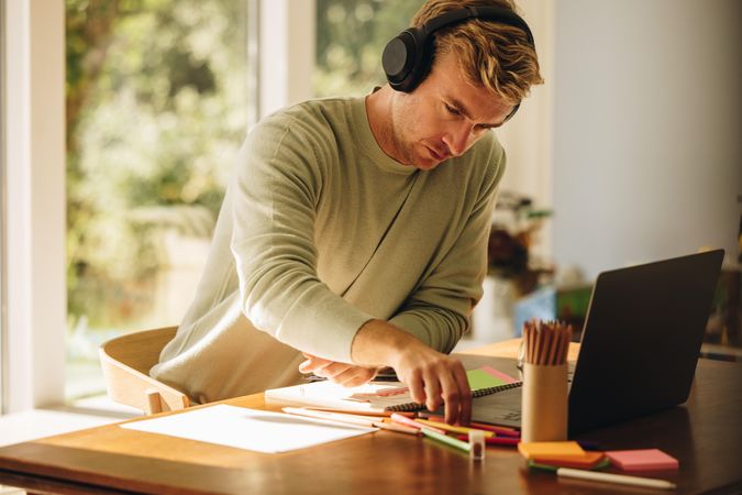 Man wearing headphones working on his illustrations at home
