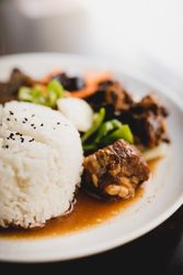Cooked tasty pork ribs with rice and vegetables