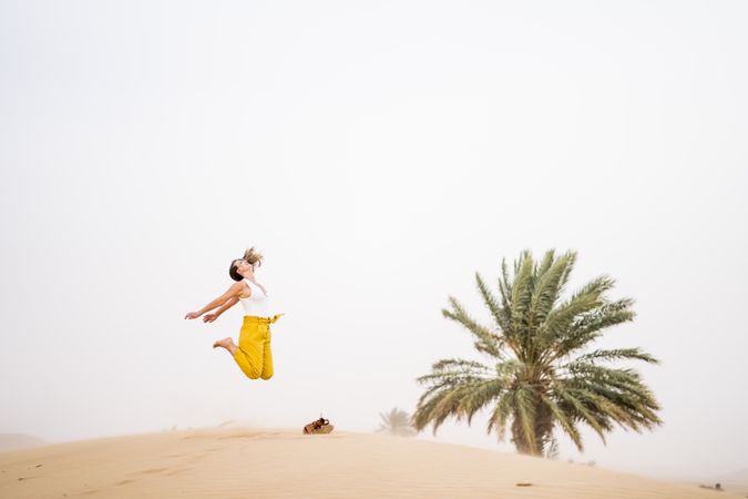 Happy woman jumping in desert