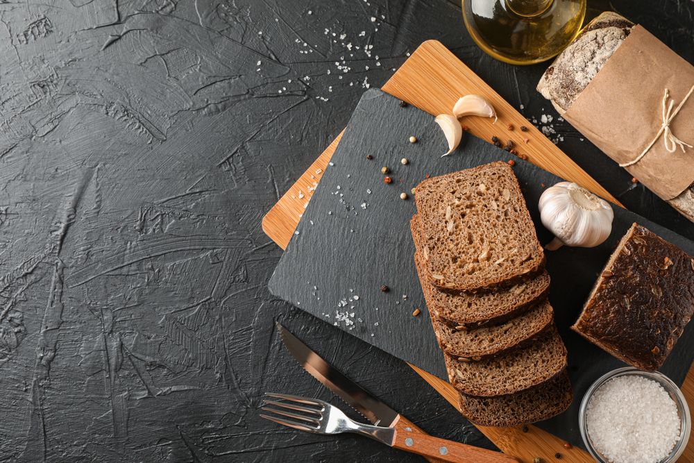 Composition with bread on cutting board, space for text and top view