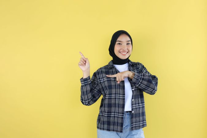 Happy Asian Muslim Woman Showing Copy Space on Finger
