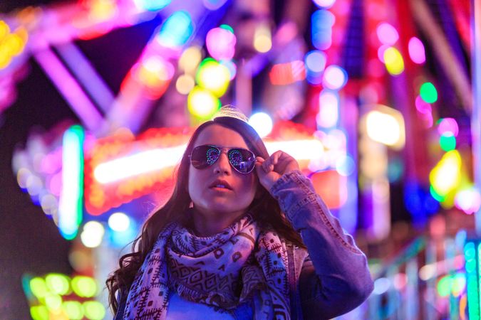Stylish young woman near illumination on street