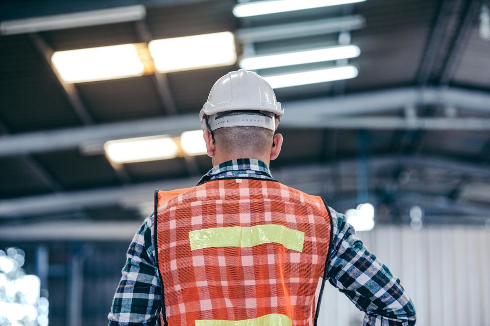 Back view of industrial engineer or factory mechanic worker with hard hat