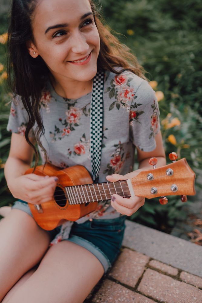 Happy modern woman playing ukulele