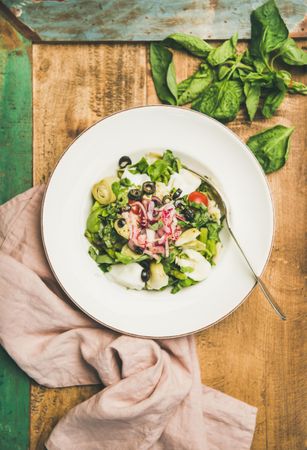 Artichoke salad in bowl, on wooden background with green trim