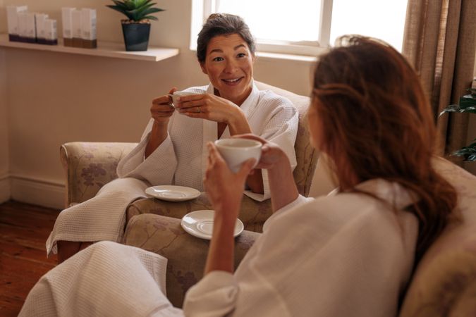 Female friends having herbal tea and chatting in spa