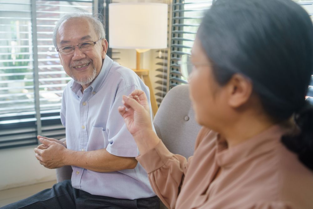 Asian couple talking together in the living room