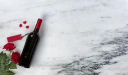 Valentine’s Day with red roses and wine on marble stone setting
