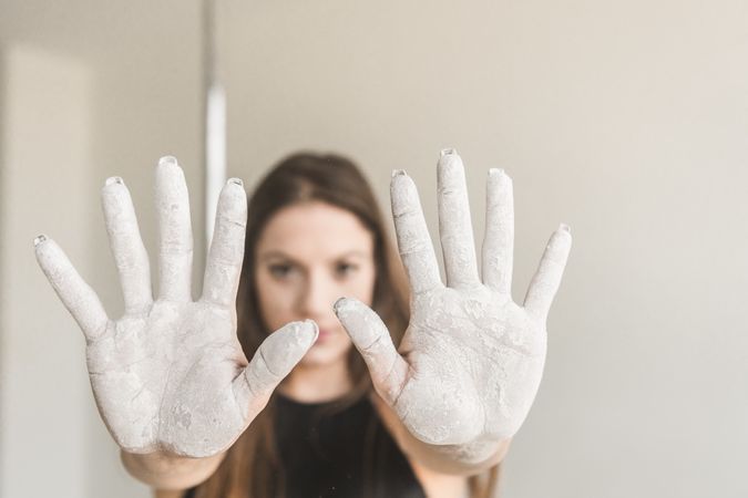 Young woman showing hands in chalk