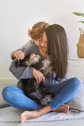 Mother and son hugging dog together at home