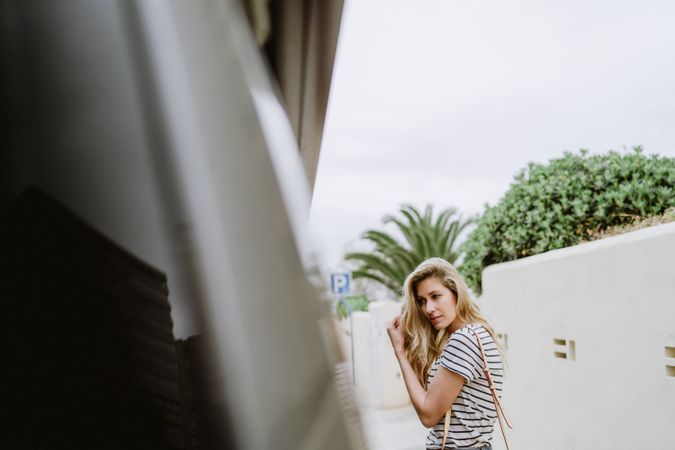 Unsure woman standing next to bus in city