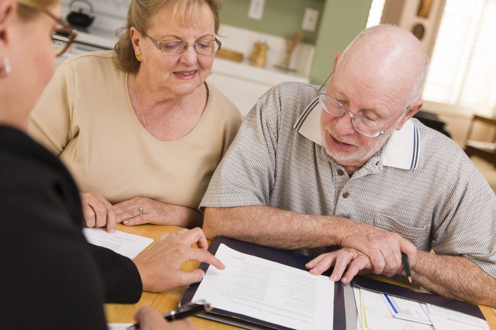 Older Adult Couple Going Over Papers in Their Home with Agent