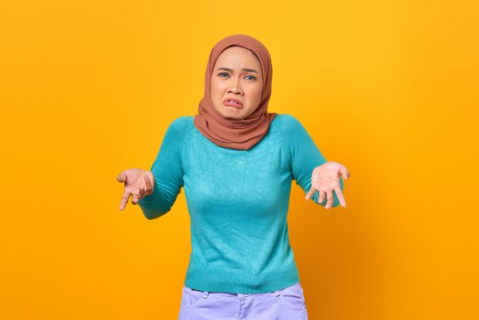 Confused Muslim woman shrugging her shoulders
