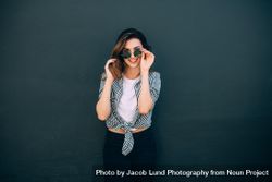 Happy looking woman standing against a wall posing for photograph 0yD9Lb