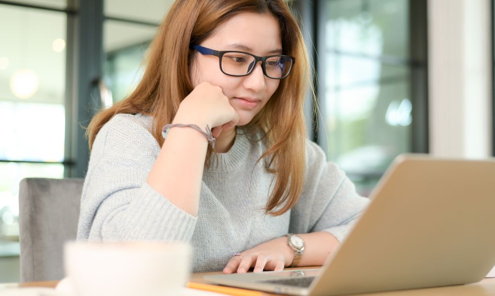 Young woman chatting online smiling.