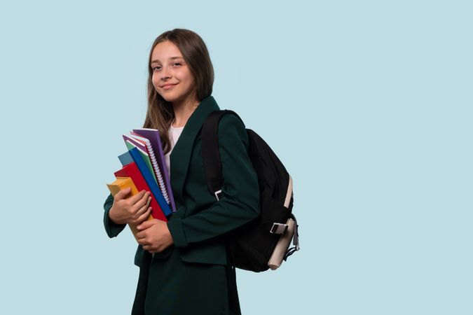 Teen girl with backpack holding books