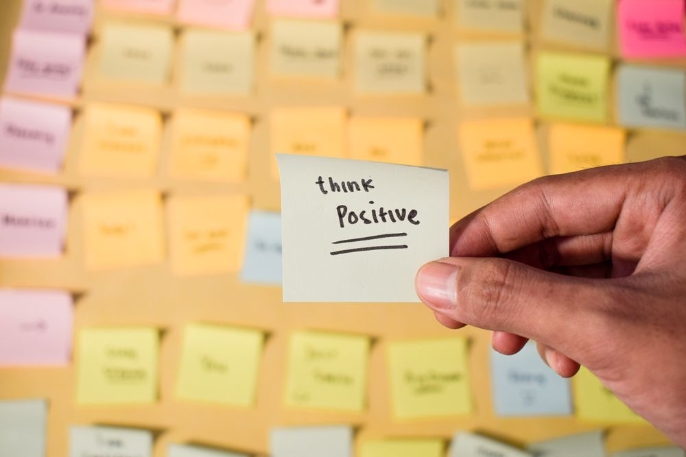 Hand hold sticky notes with words Think Positive