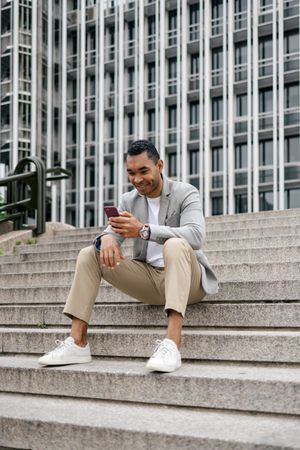 Man sitting on stairs using smartphone