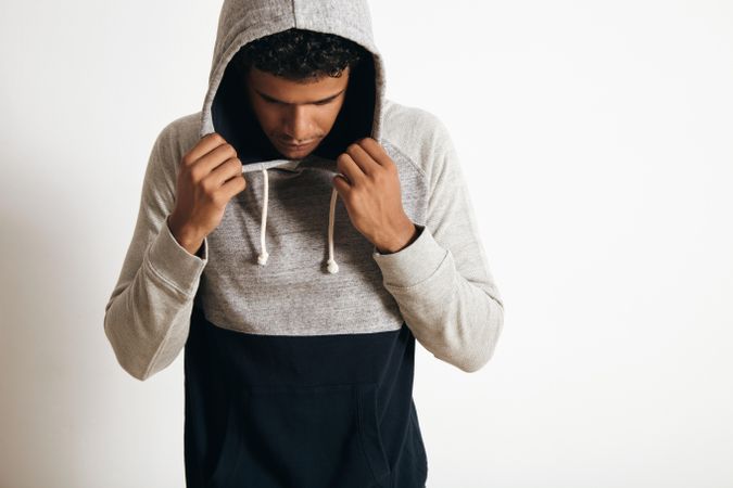 Serious man with head down holding hoodie