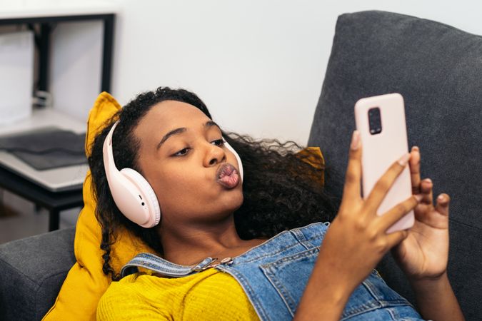 Young woman enjoys music and phone