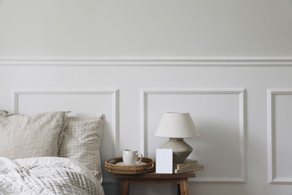 Bedside table with tray of coffee, lamp with blank card