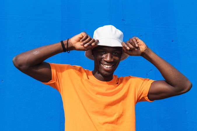 Black man in bright sporty outfit and cap