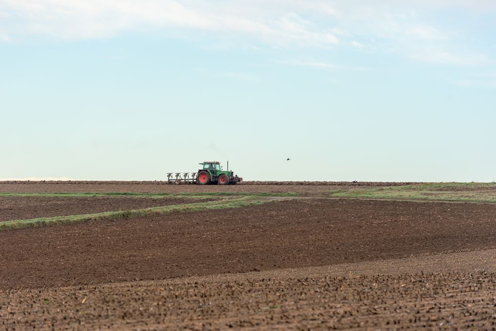 Tractor plowing agricultural fields outside of Stuttgart city, Germany