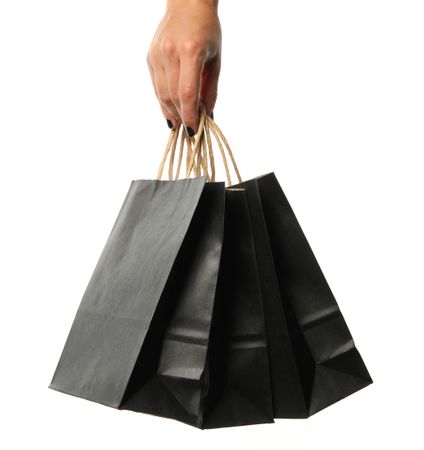 Female hand hold paper bags, isolated on bright background