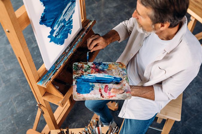 Top view of painter with palette and easel