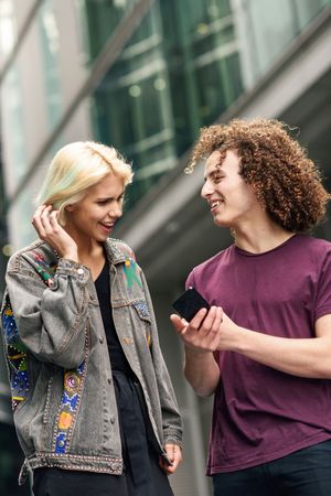 Man and woman looking down at cell phones walking on British city street